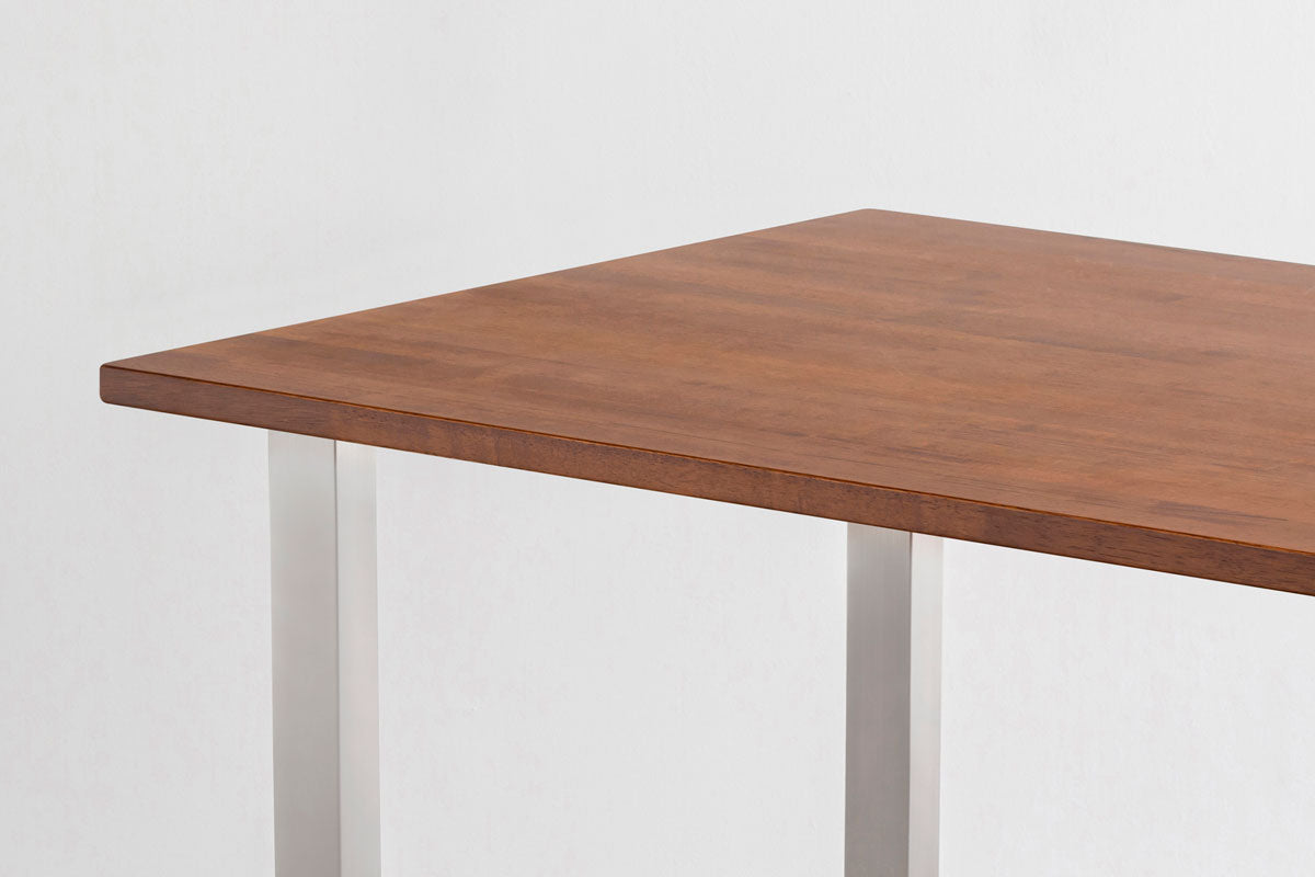 Gemoneの艶やかなチークブラウンのラバーウッド材とマットな質感のステンレス脚を組み合わせた重厚感のあるテーブル・クローズアップ