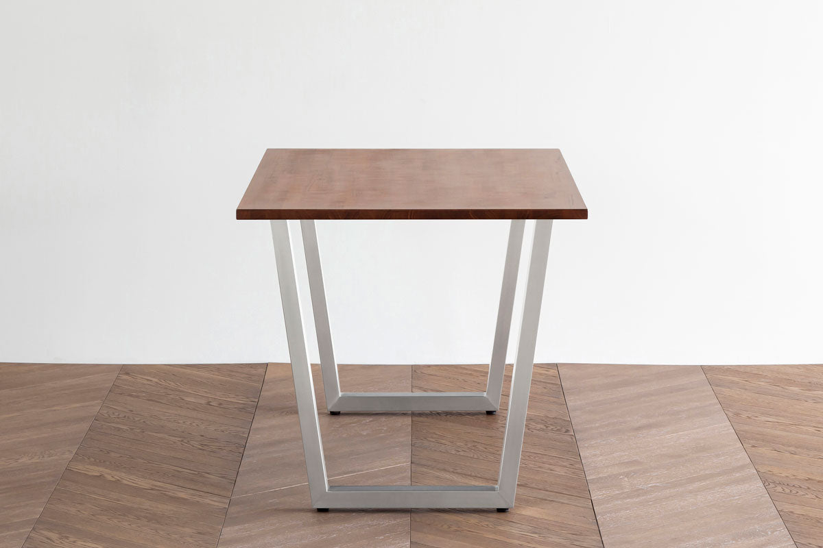 Gemoneの艶やかなチークブラウンのラバーウッド材とマットな質感のI型のステンレス脚を組み合わせた重厚感のあるテーブル