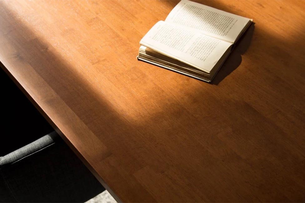 Gemoneの艶やかなチークブラウンのラバーウッド材とマットな質感のステンレス脚を組み合わせた重厚感のあるテーブル(天板)・クローズアップ