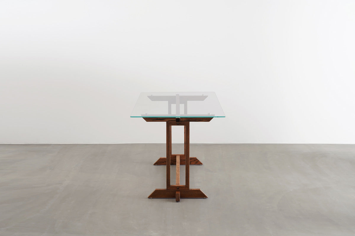 Favricaのガラス天板とブラウンのIライン木製脚を組み合わせたダイニングテーブル（横からのアングル）