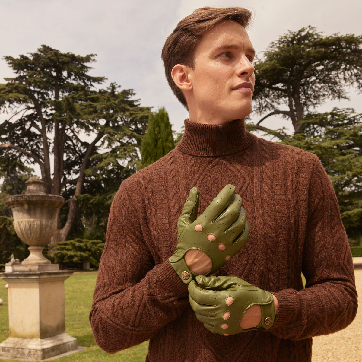 Man wearing classic leather driving gloves in lincoln green