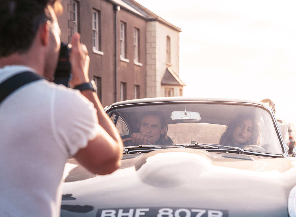 Photographer taking a picker of someone in side a jaguar e-type