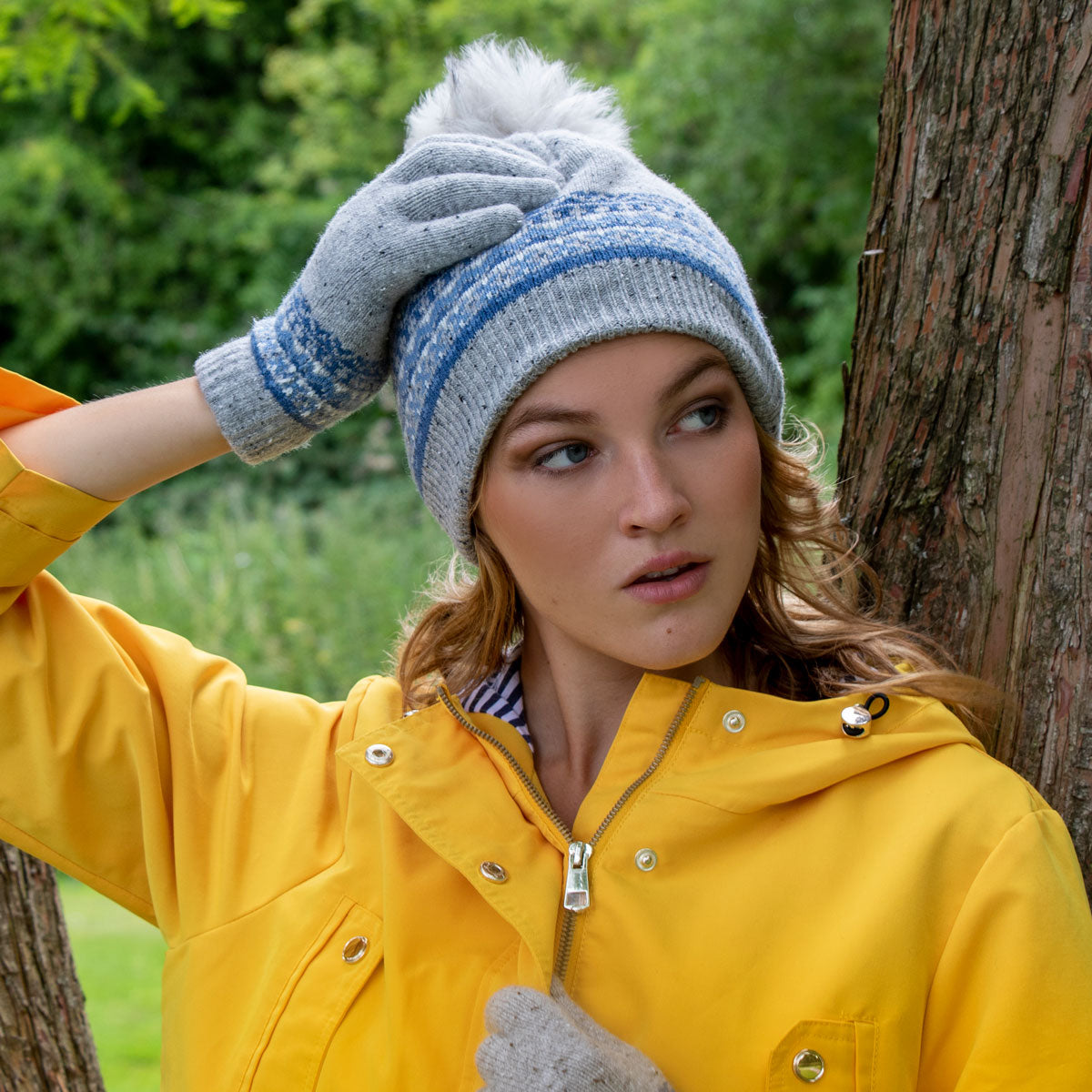 Woman wearing fair isle wool blend knitted pom pom hat in dove grey