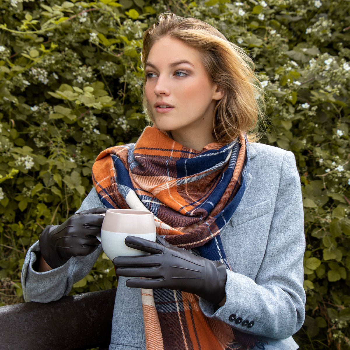 Woman wearing contrasting-check scarf in orange/navy