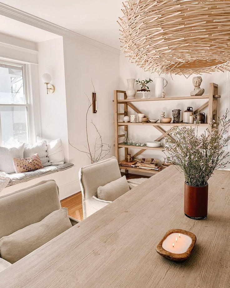 White and wood natural dining room with a brass and glass dining room wall sconce