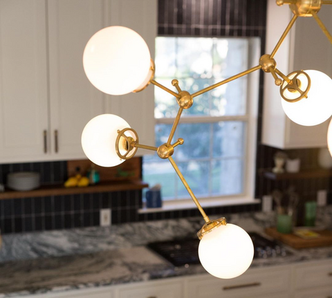 Chimie Chandelier a raw brass and glass light fixture for larger spaces