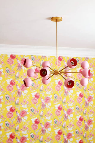 Pink Orion chandelier on yellow and pink floral wallpaper