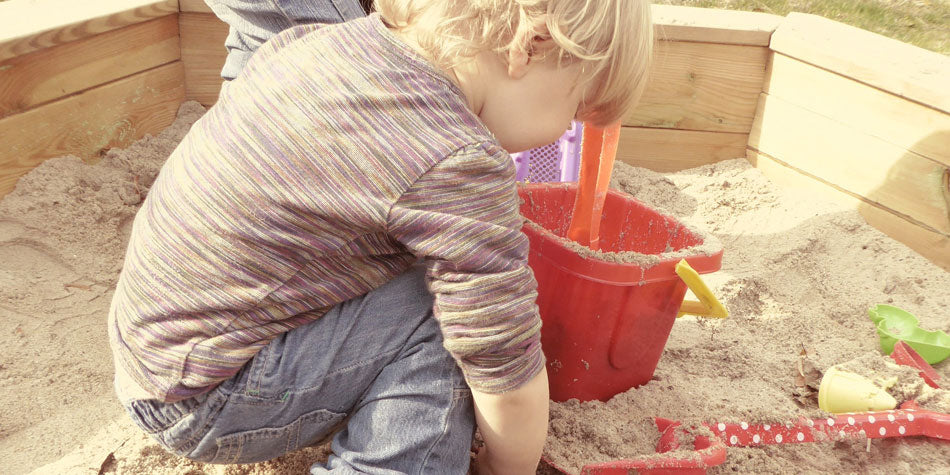 kid playing in a sandbox