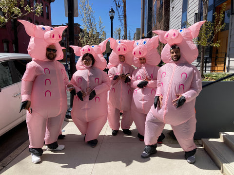 Team of players dressed as pigs at a Socially Distanced Team Building Event by CluedUpp Games. This team are walking down the street in Australia in inflatable pig costumes.