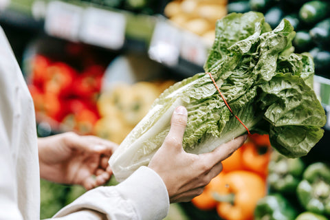 Person picking produce at the grocery store 