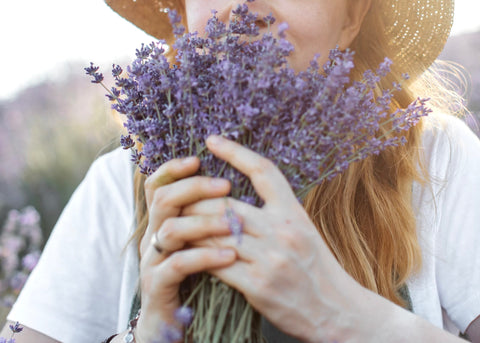 Mujer que huele flores de lavanda