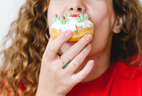 Woman biting down on a doughnut