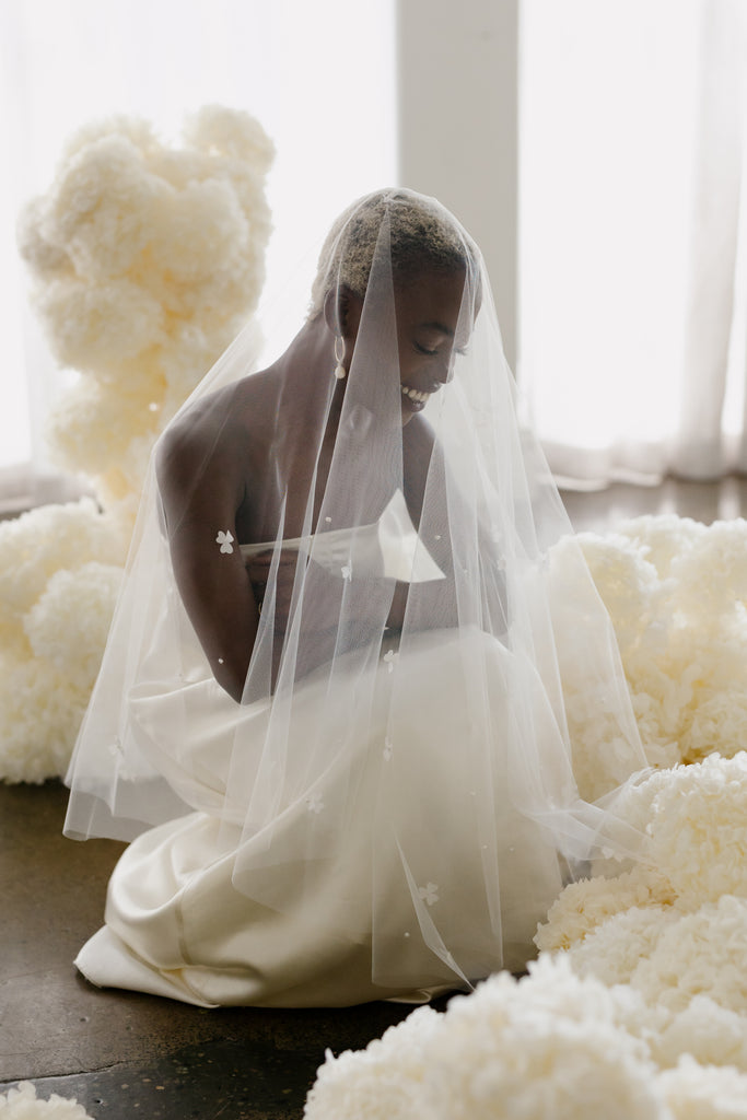 Bride sits in floral installation of dried hydrangeas 