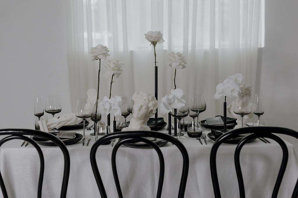 monochrome style table is set with bentwood chairs 