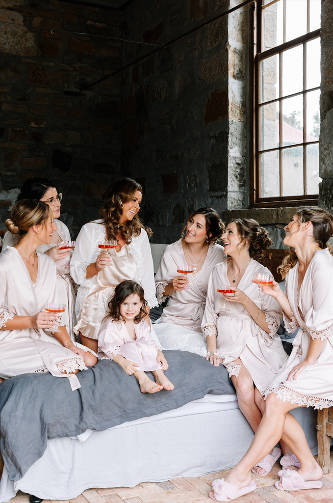 Bride sits with her bridesmaids and flower girl