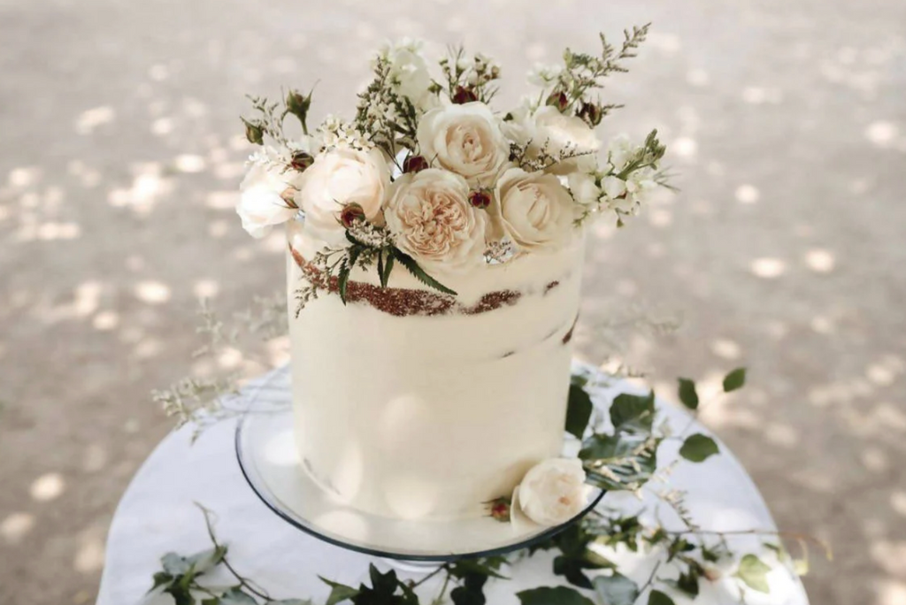 Naked single tier buttercream wedding cake with dried flowers on the top and around