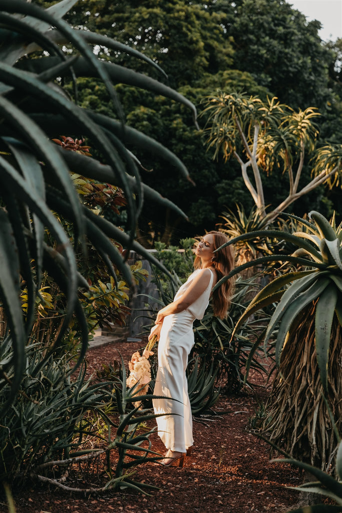 Bohemian bride stands in the sun of a Moroccan style garden.