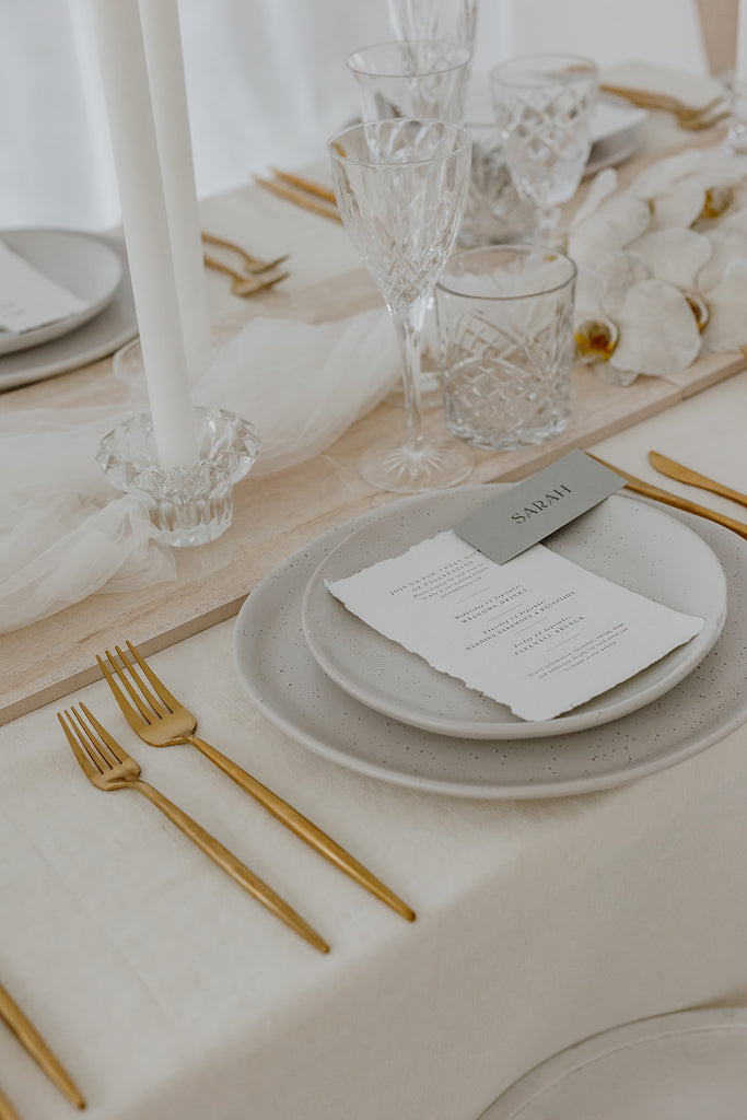 Wedding table styled with stone, tulle and gold cutlery 