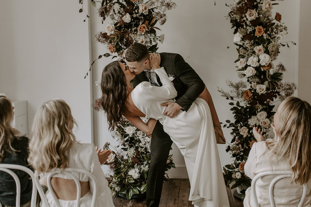 bride and groom dip kiss at wedding ceremony