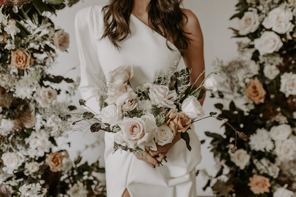 Bride holding blush, toffee and cream wedding bouquet
