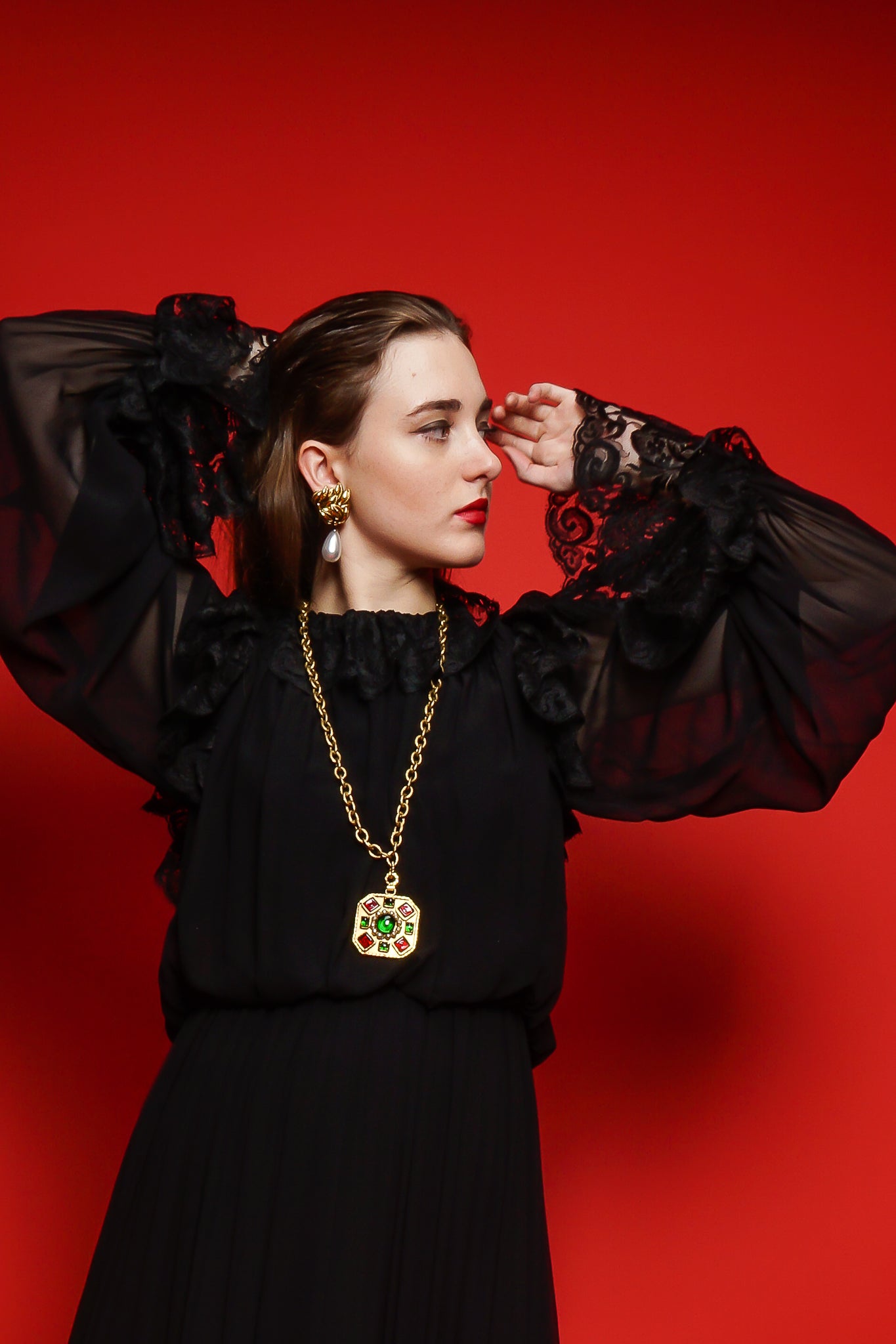 Girl in black Richilene lace dress & Chanel necklace on red background at Recess Los Angeles