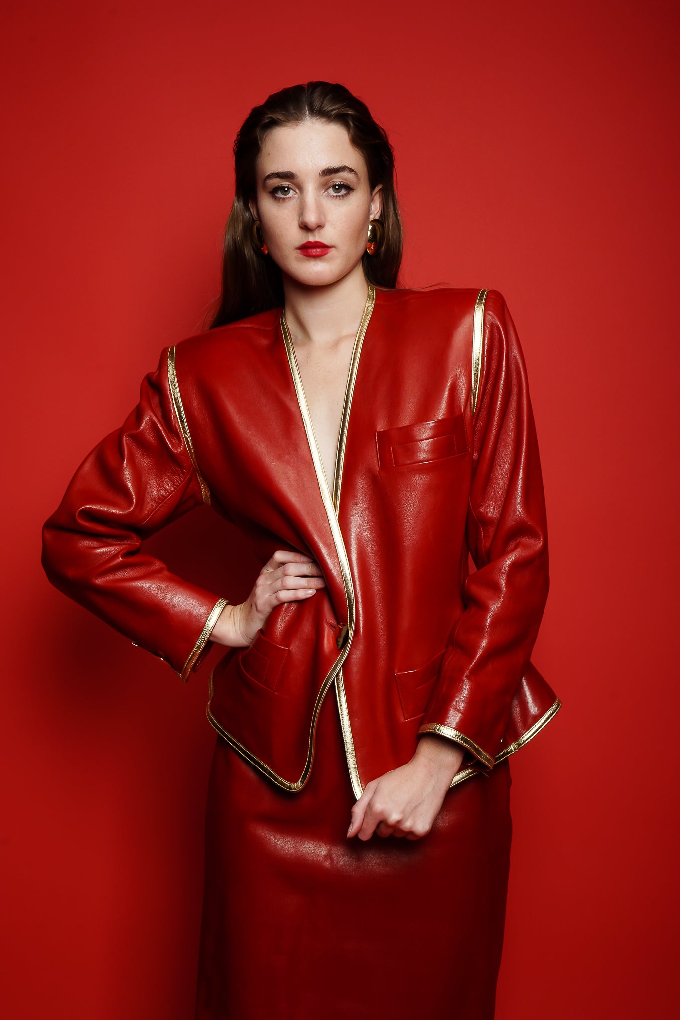 Girl in red vintage Yves Saint Laurent leather suit on red background at Recess Los Angeles