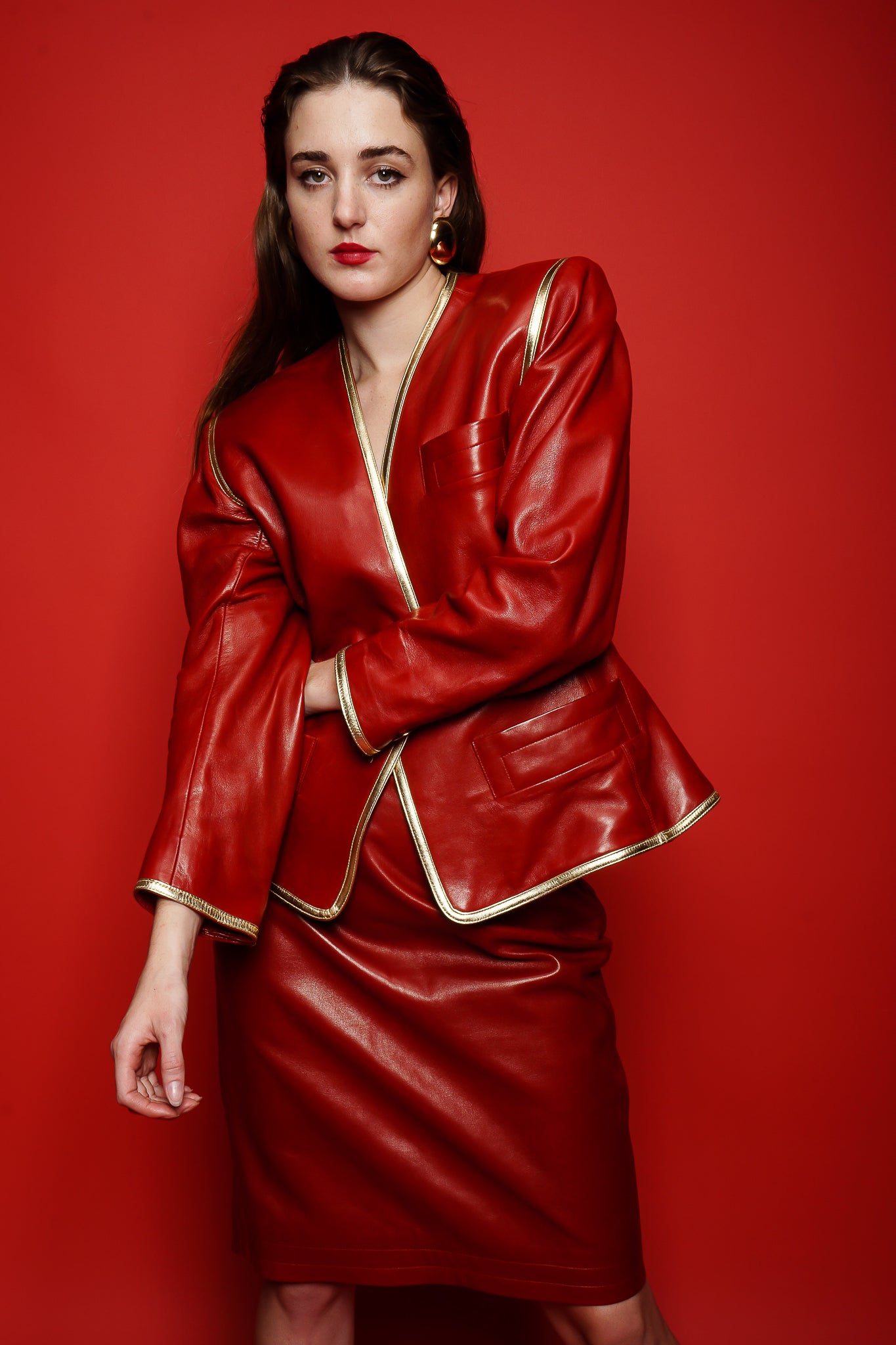 Girl in red vintage Yves Saint Laurent leather suit on red background at Recess Los Angeles