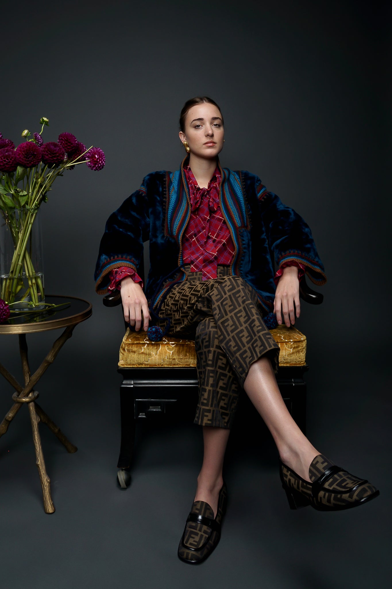 Recess Designer Vintage Consignment Girl wearing blue faur fur & fendi zucca pant sitting in chair