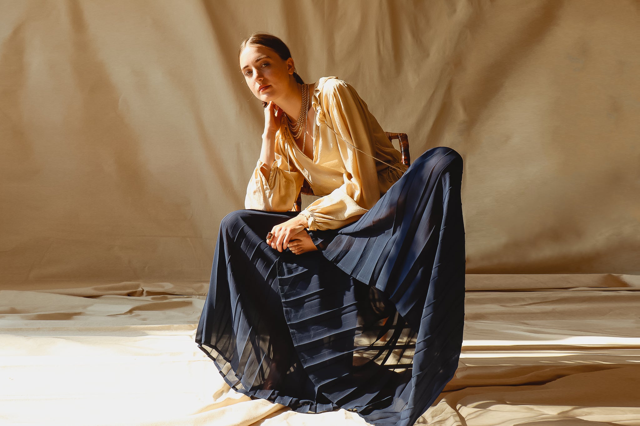 Recess Vintage Consignment LA Girl sitting in beige YSL Blouse & Mila Schon Sheer Palazzo Pants