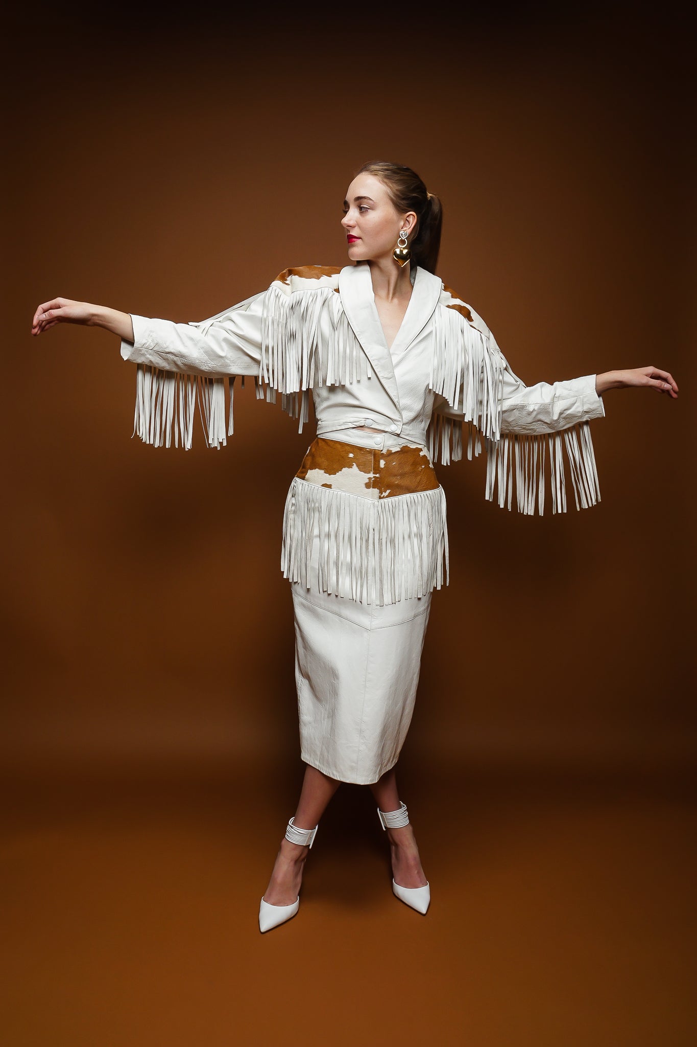 girl in Dali Melame white leather haircalf fringe jacket & skirt set on brown at Recess Los Angeles