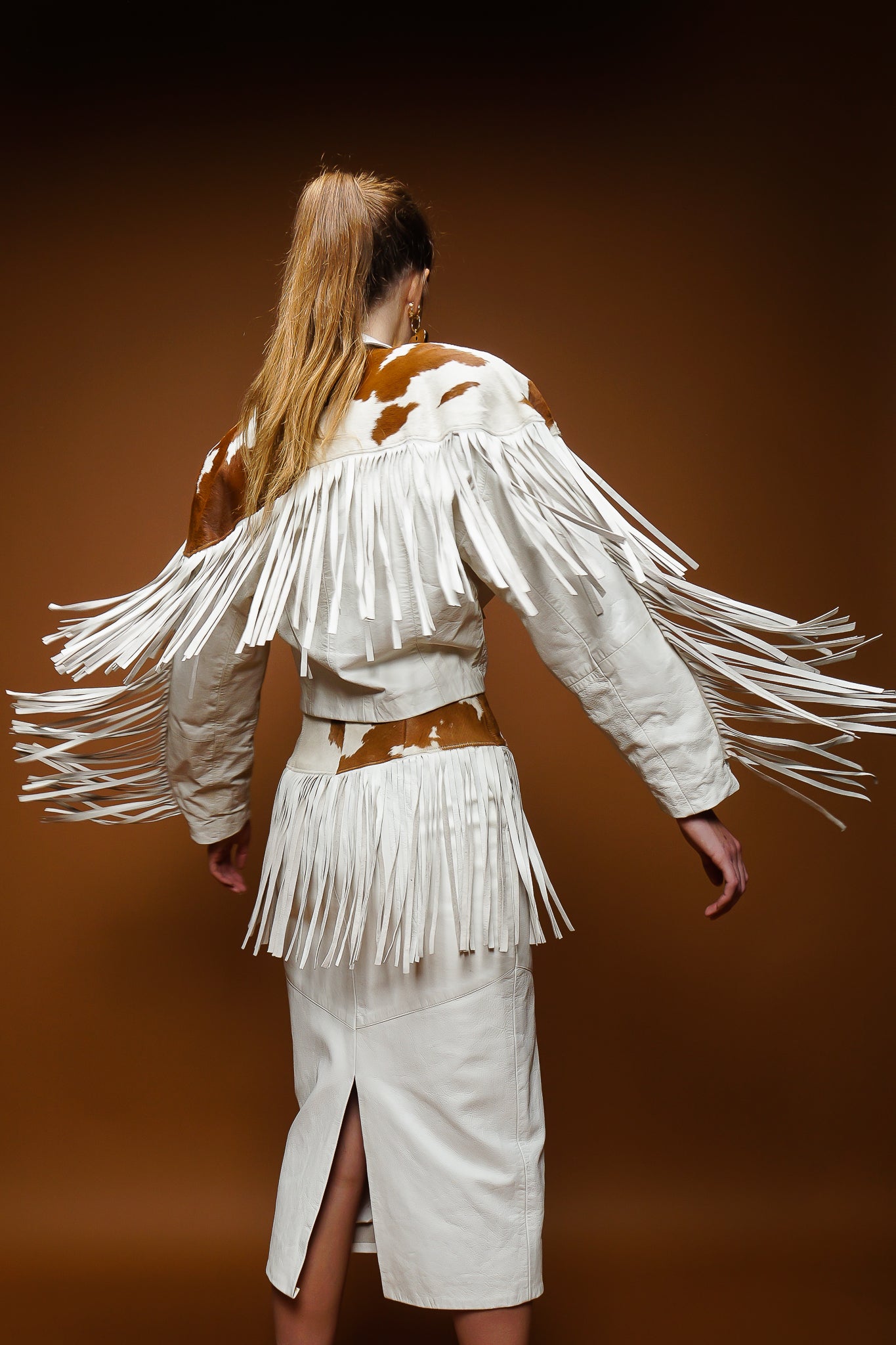 girl in Dali Melame white leather haircalf fringe jacket & skirt set on brown at Recess Los Angeles
