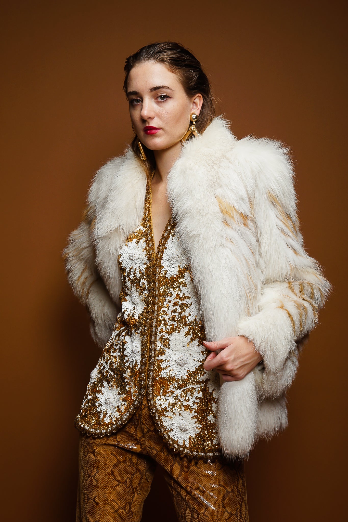 girl in Saga Fox fur jacket, Valentina sequin vest, Braude snake pant on brown @ Recess Los Angeles