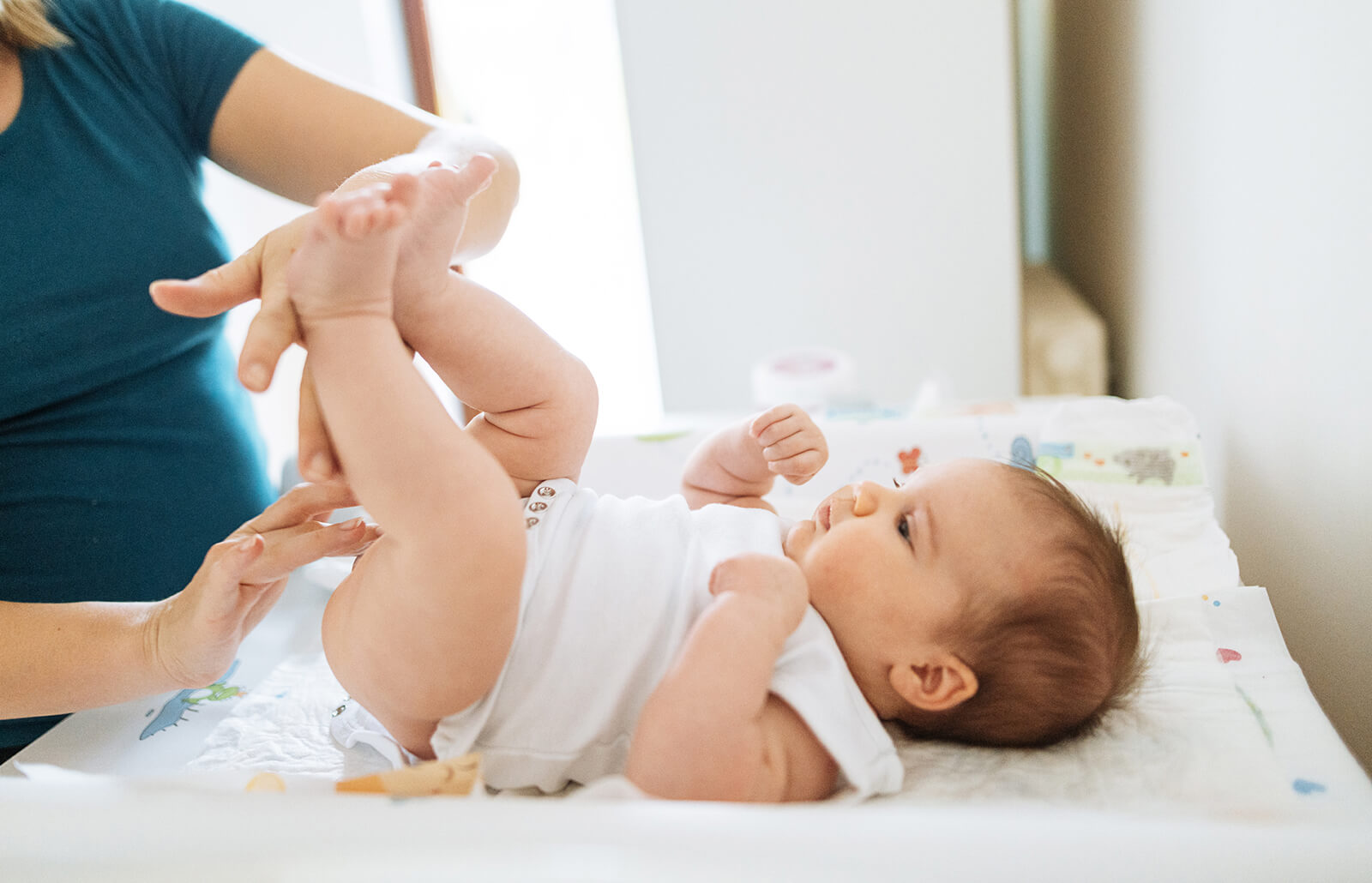 Mom applying cream to baby’s butt