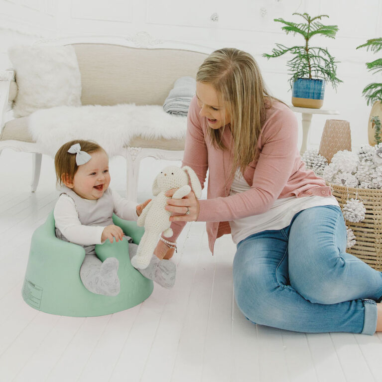 baby in a floor seat