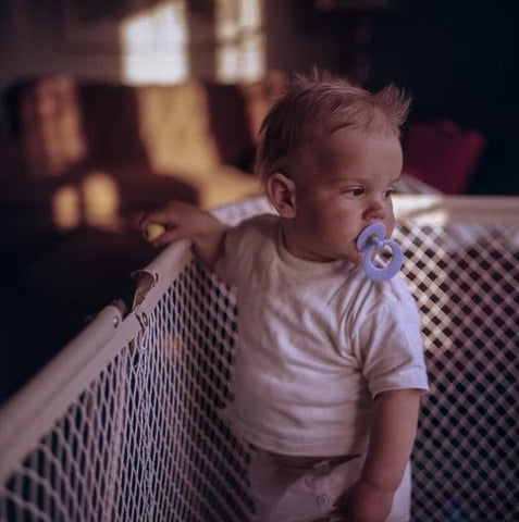 Baby with a binkie in a crib self-soothing