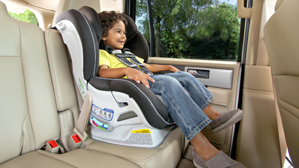 a kid in a convertible car seat