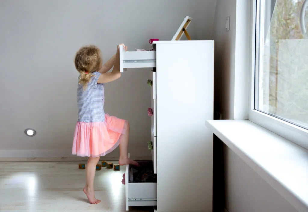 Girl tilting dresser