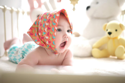 Happy Baby in a crib with teddy bears