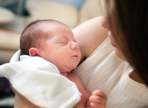 a mother singing her baby to sleep