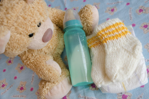 a plush bear and baby bottle