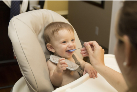 an infant eating from a spoon