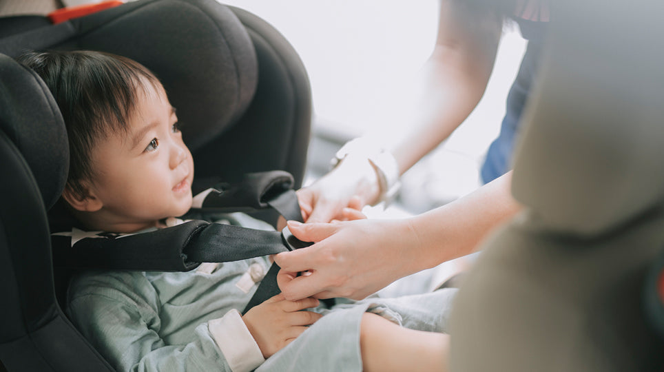 infant being put in a car seat