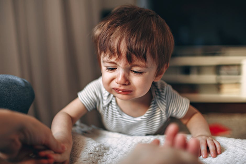  A sad baby with brown hair. 