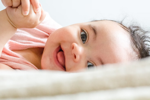  A baby laughing while laying in bed