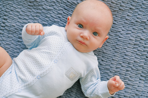  Cute baby with blue eyes staring into the camera.