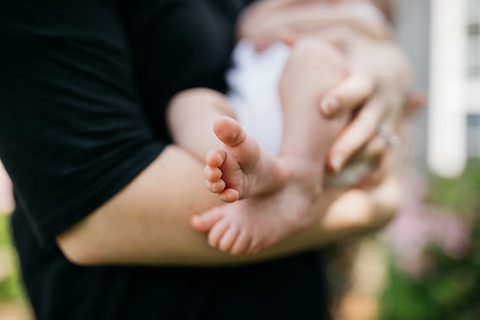 Parent tenderly holding their sleeping baby.