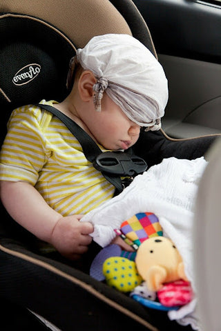 A baby sleeping in a car seat.