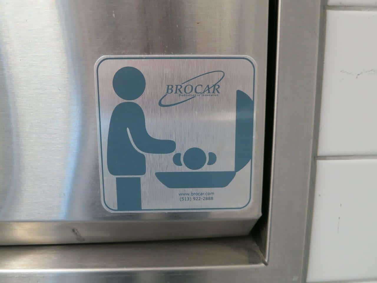 a silver baby changing station in a public restroom