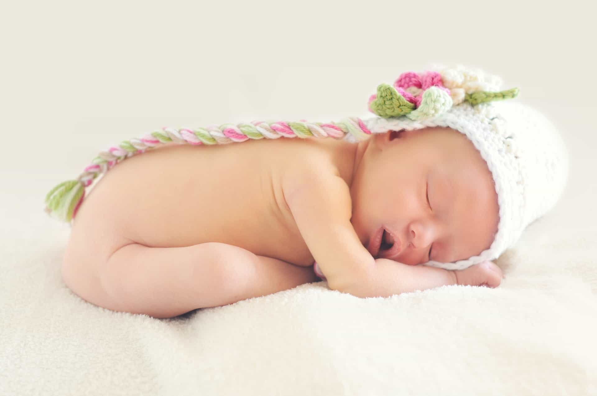 Sleeping baby on its side with cute hat