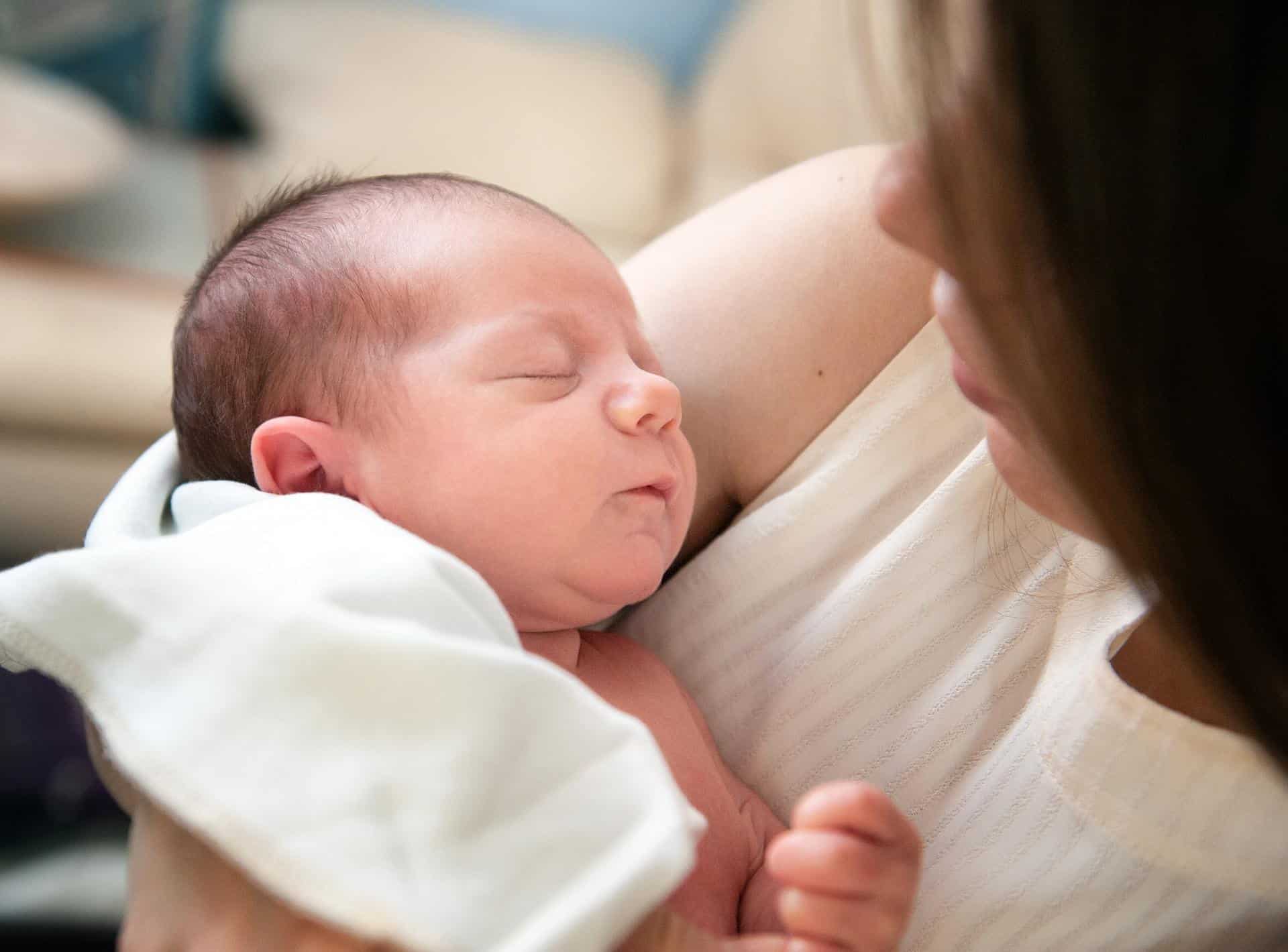 mother holding small sleeping baby